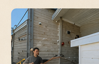 Technician working beside a house exterior